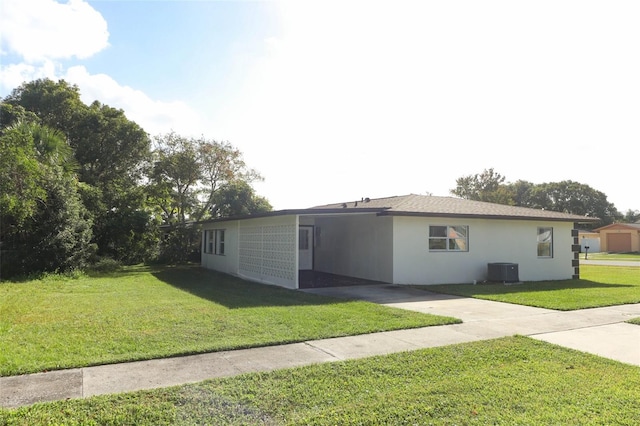 view of front of house featuring a front yard and central AC