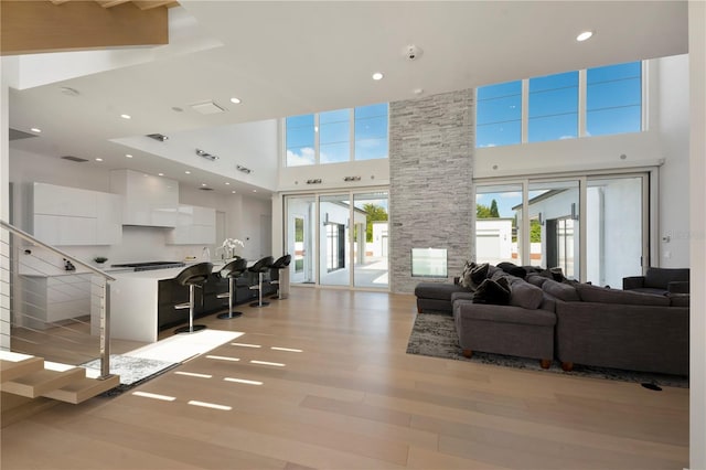 living room featuring light hardwood / wood-style flooring and a high ceiling