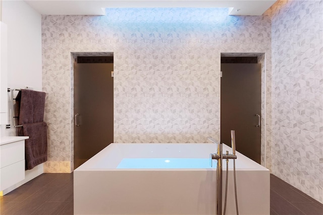 bathroom with a bathtub, vanity, and tile patterned flooring