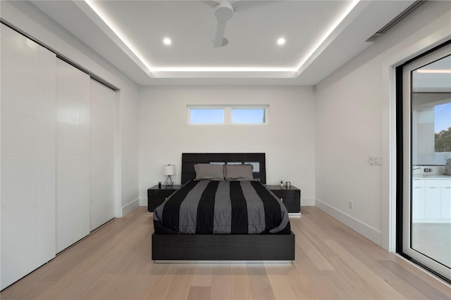 bedroom featuring multiple windows, ceiling fan, and light wood-type flooring