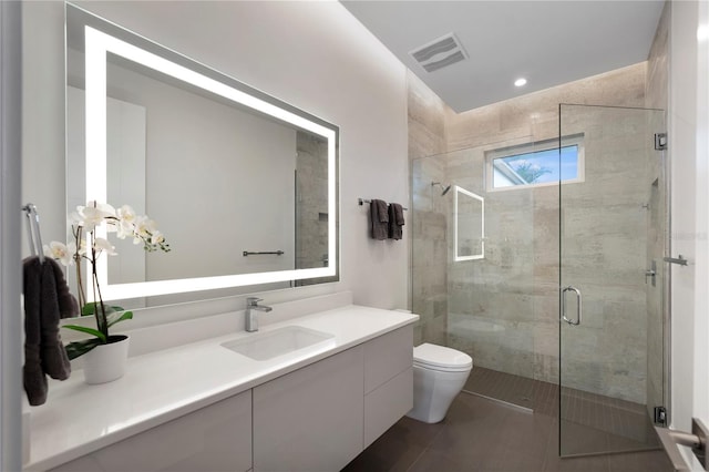 bathroom featuring tile patterned flooring, vanity, toilet, and an enclosed shower