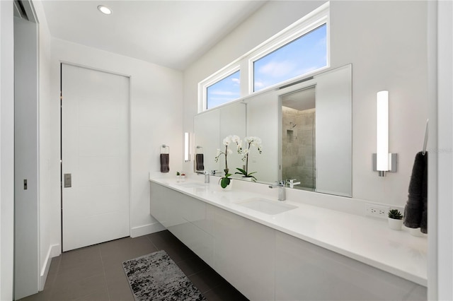 bathroom with tile patterned flooring, a tile shower, and vanity