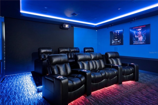 carpeted cinema featuring a raised ceiling