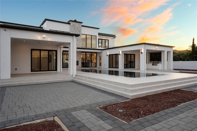 back house at dusk with a patio