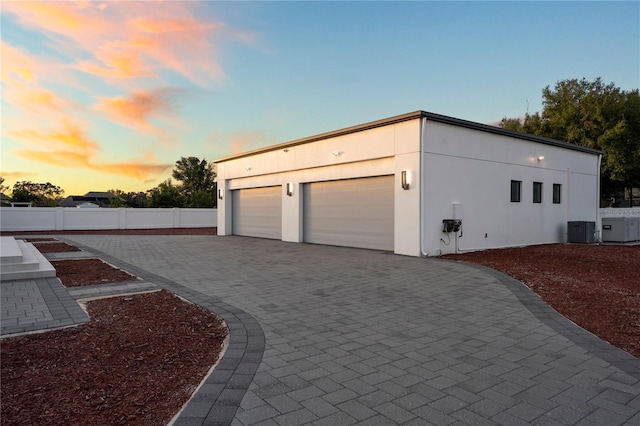 garage at dusk featuring cooling unit