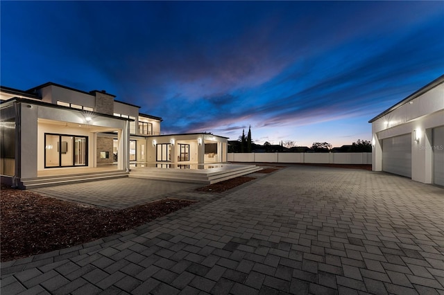 back house at dusk with a garage