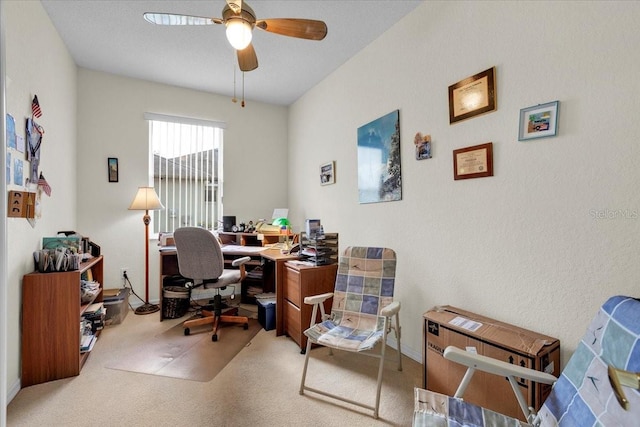 carpeted office space featuring ceiling fan