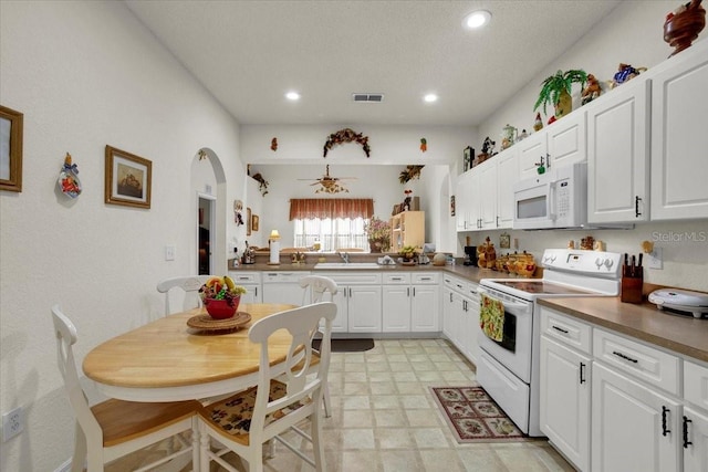 kitchen with ceiling fan, white appliances, light tile flooring, sink, and white cabinetry