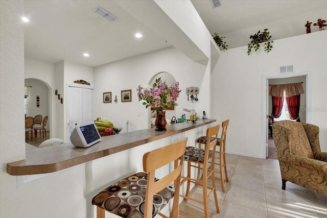 kitchen featuring a breakfast bar area and light tile floors