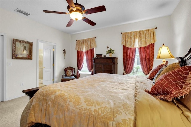 bedroom with ceiling fan, ensuite bathroom, and carpet floors