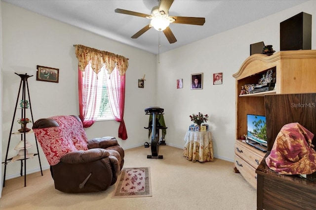 living area with carpet and ceiling fan