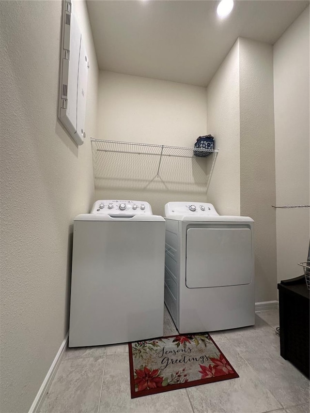 laundry room with washer and clothes dryer and light tile floors