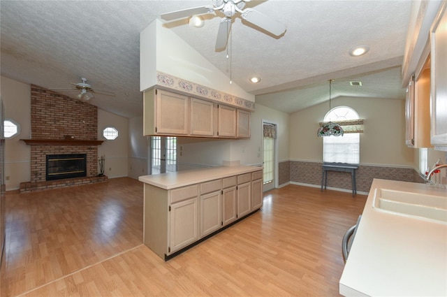 kitchen featuring ceiling fan, vaulted ceiling, and light hardwood / wood-style floors