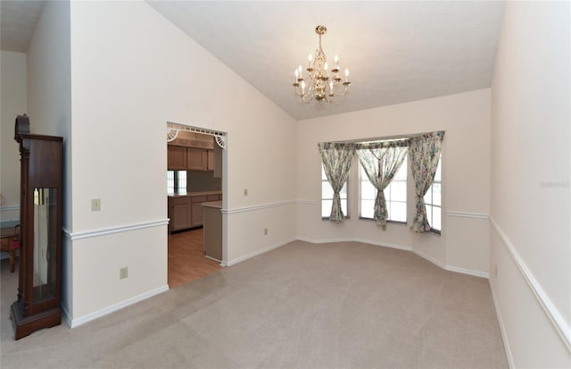 unfurnished room featuring a healthy amount of sunlight, high vaulted ceiling, carpet floors, and a chandelier