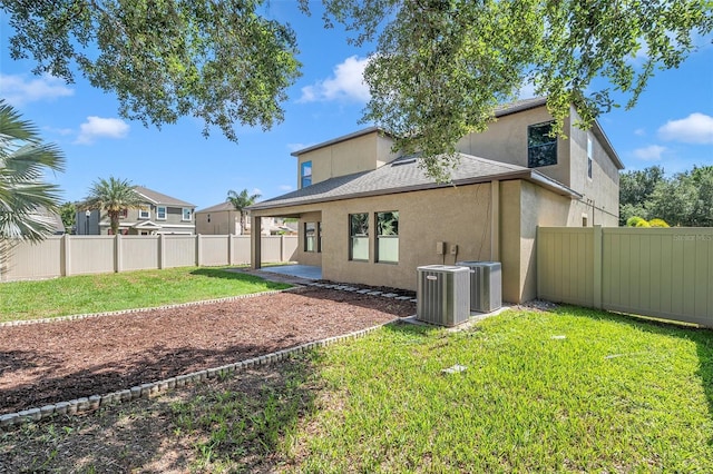 rear view of house featuring central air condition unit, a fenced backyard, and stucco siding