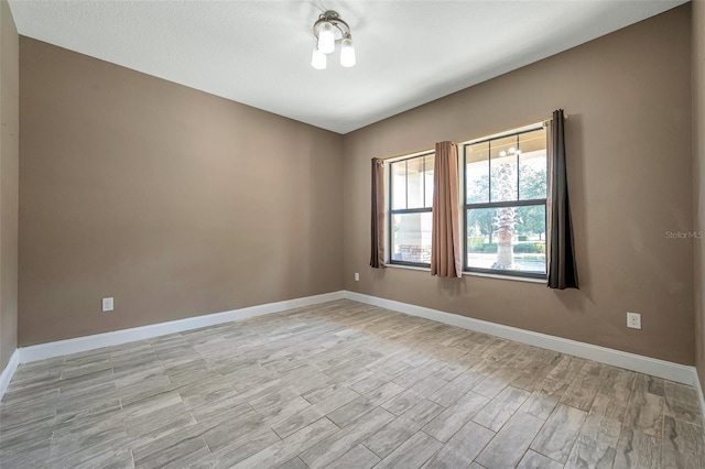 unfurnished room with light wood-style floors and baseboards