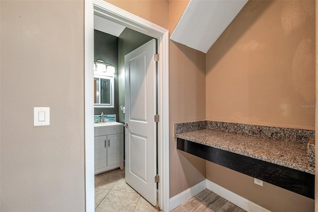 bathroom with tile patterned flooring, vanity, and baseboards