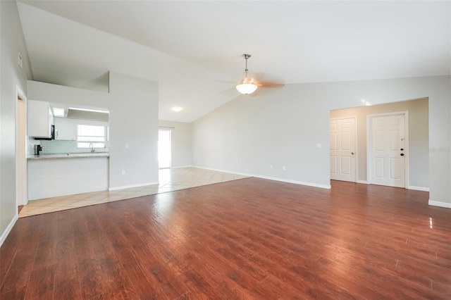 unfurnished living room featuring hardwood / wood-style floors, sink, ceiling fan, and lofted ceiling