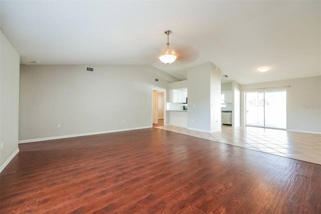 unfurnished living room featuring vaulted ceiling and wood-type flooring