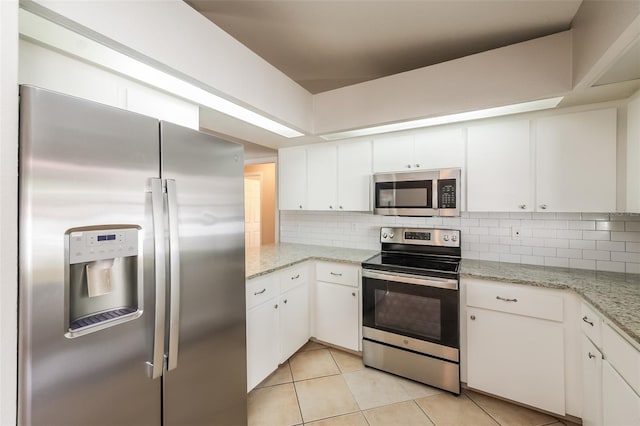 kitchen with backsplash, appliances with stainless steel finishes, white cabinetry, and light tile floors