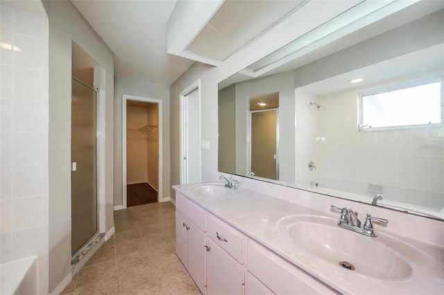 bathroom with a shower with door, tile flooring, oversized vanity, and dual sinks