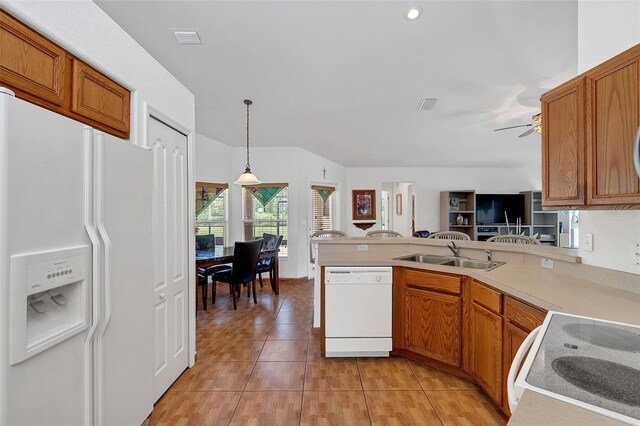 kitchen featuring sink, white appliances, light tile patterned floors, decorative light fixtures, and kitchen peninsula