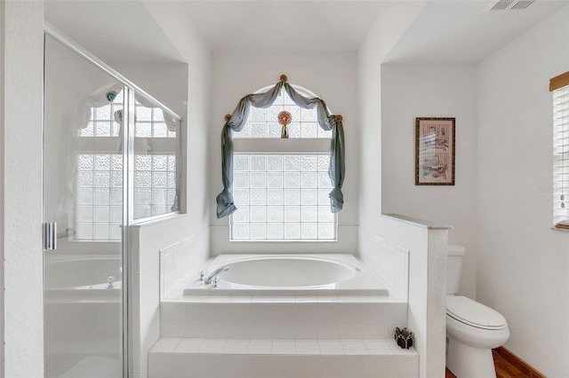 bathroom featuring wood-type flooring, toilet, separate shower and tub, and a wealth of natural light