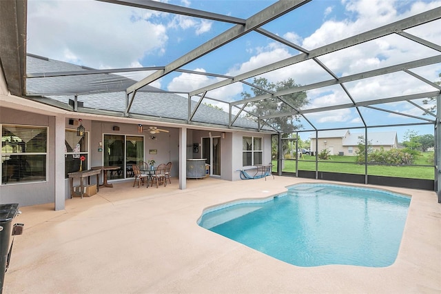 view of swimming pool featuring ceiling fan, exterior bar, glass enclosure, and a patio area