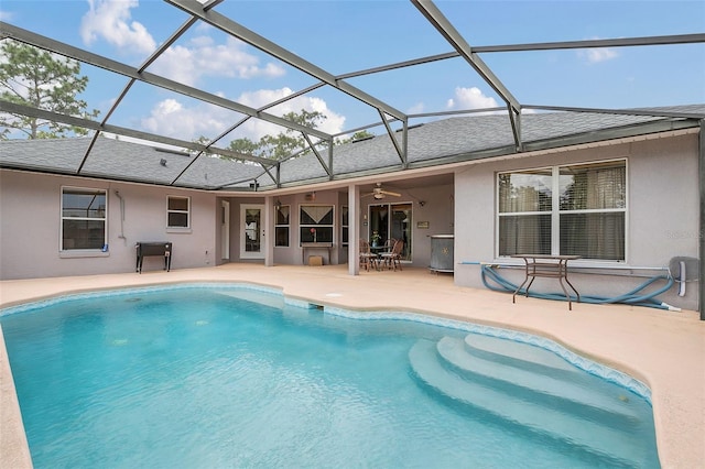 view of pool featuring a patio area, ceiling fan, and glass enclosure