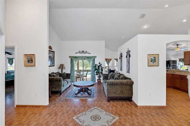 living room featuring light tile patterned floors, vaulted ceiling, and ceiling fan