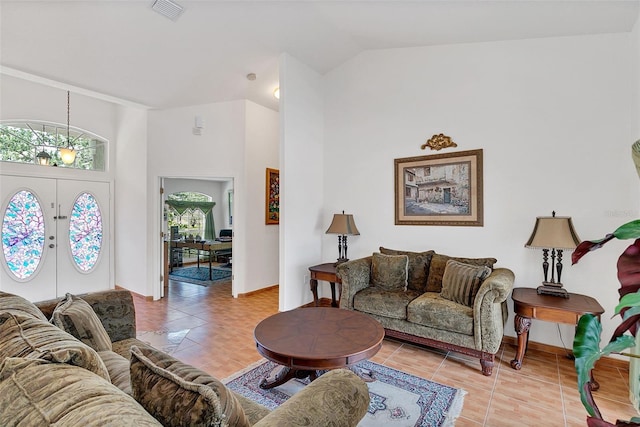 living room featuring light tile patterned floors, vaulted ceiling, and french doors