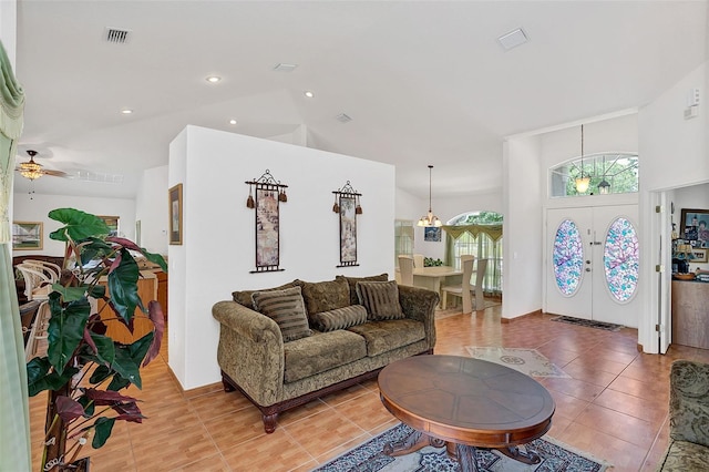 living room featuring tile patterned floors, high vaulted ceiling, and french doors