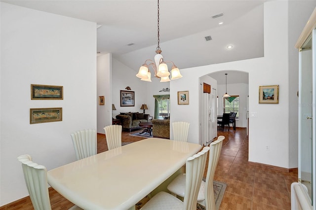 tiled dining room featuring lofted ceiling and a notable chandelier