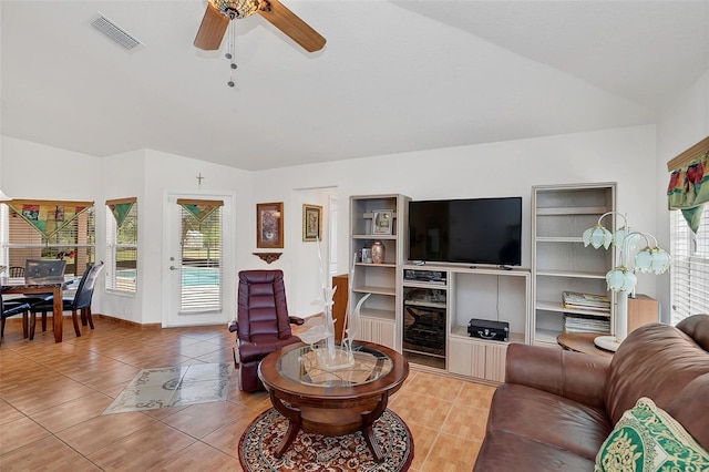 living room with vaulted ceiling, plenty of natural light, tile patterned floors, and ceiling fan