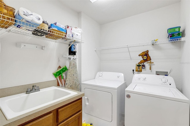 laundry room featuring separate washer and dryer, sink, and cabinets