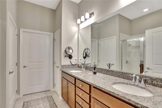 bathroom with tile flooring, a shower with shower door, oversized vanity, and double sink