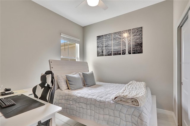 tiled bedroom featuring ceiling fan and a closet