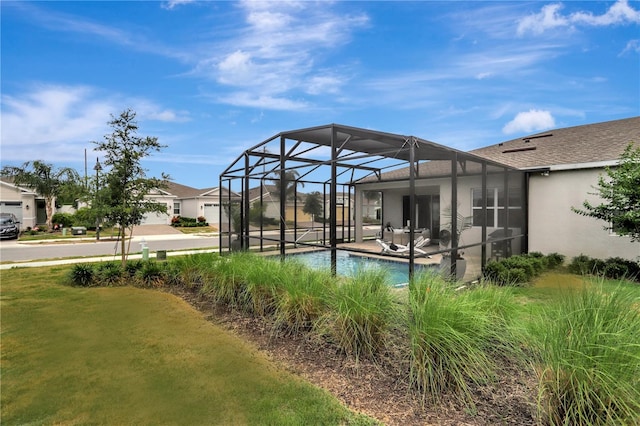 view of yard featuring glass enclosure and a patio