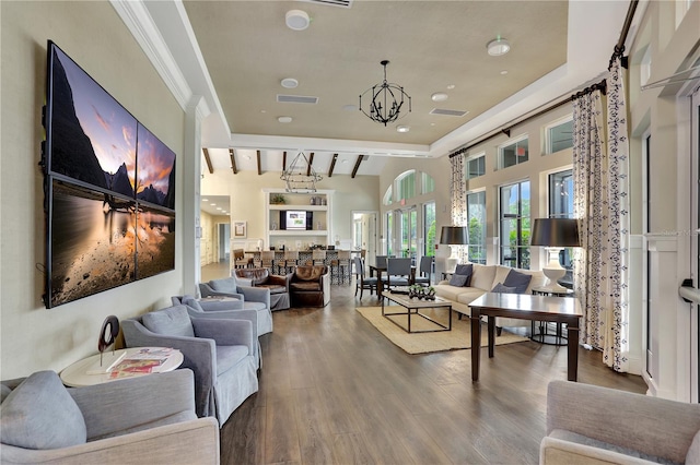 living room featuring a notable chandelier, lofted ceiling with beams, ornamental molding, and wood-type flooring