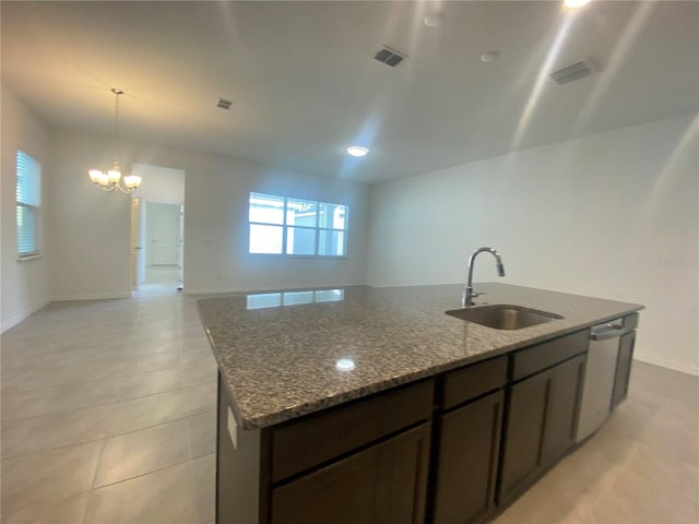 kitchen featuring hanging light fixtures, sink, stainless steel dishwasher, and a kitchen island with sink