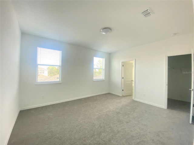 unfurnished bedroom featuring a spacious closet and carpet flooring