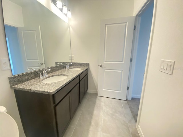 bathroom with vanity with extensive cabinet space, dual sinks, and tile floors