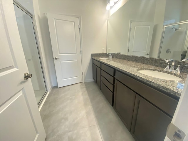 bathroom with tile floors, dual sinks, a shower with shower door, and oversized vanity