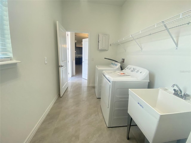 laundry area with washer and clothes dryer, sink, and light tile floors