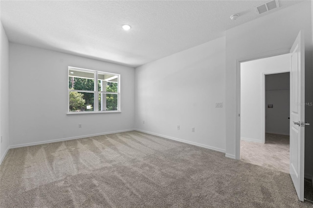 carpeted spare room featuring a textured ceiling