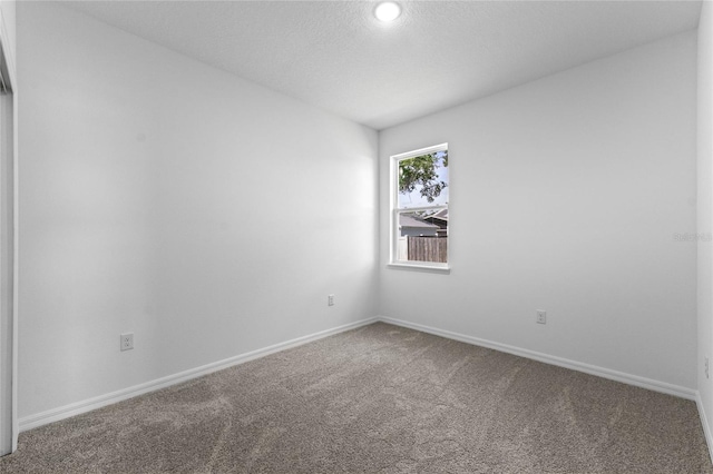 carpeted empty room featuring a textured ceiling