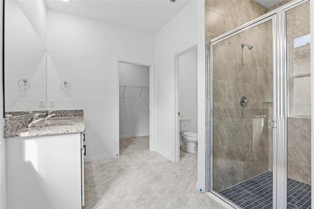 bathroom with vanity, toilet, and a shower with shower door