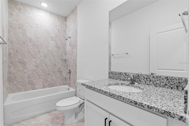 full bathroom with tiled shower / bath, vanity, toilet, and tile patterned floors