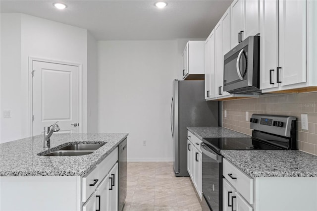 kitchen with stainless steel appliances, sink, decorative backsplash, white cabinetry, and light stone counters