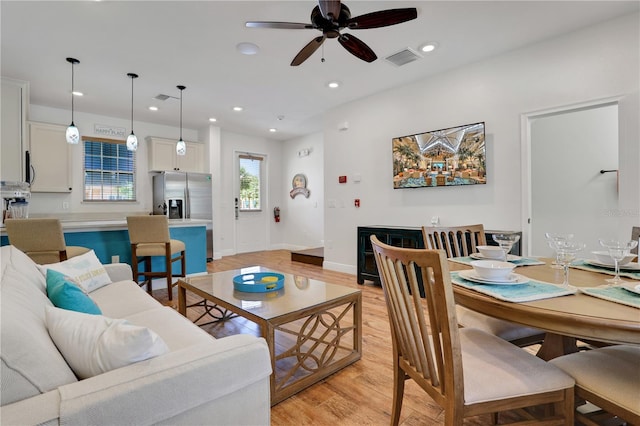 living room with light hardwood / wood-style floors and ceiling fan